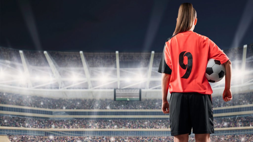 Image of college women soccer player holding soccer ball